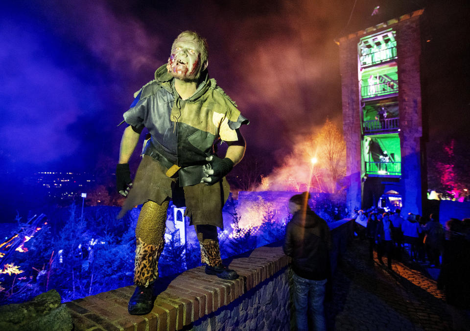 An actor stands on a wall of the medieval Frankenstein Castle about 35 kilometers (22 miles) south of Frankfurt, Germany Saturday, Oct. 26, 2019. The Medieval Frankenstein Castle has become a favorite haunt for Germans celebrating Halloween, a tradition that’s become increasingly popular in continental Europe in recent years. The crumbling castle, located about 35 kilometers (22 miles) south of Frankfurt, has been staging spooky festivals since 1977 featuring monsters, gore and spine-chilling live shows. (AP Photo/Michael Probst)