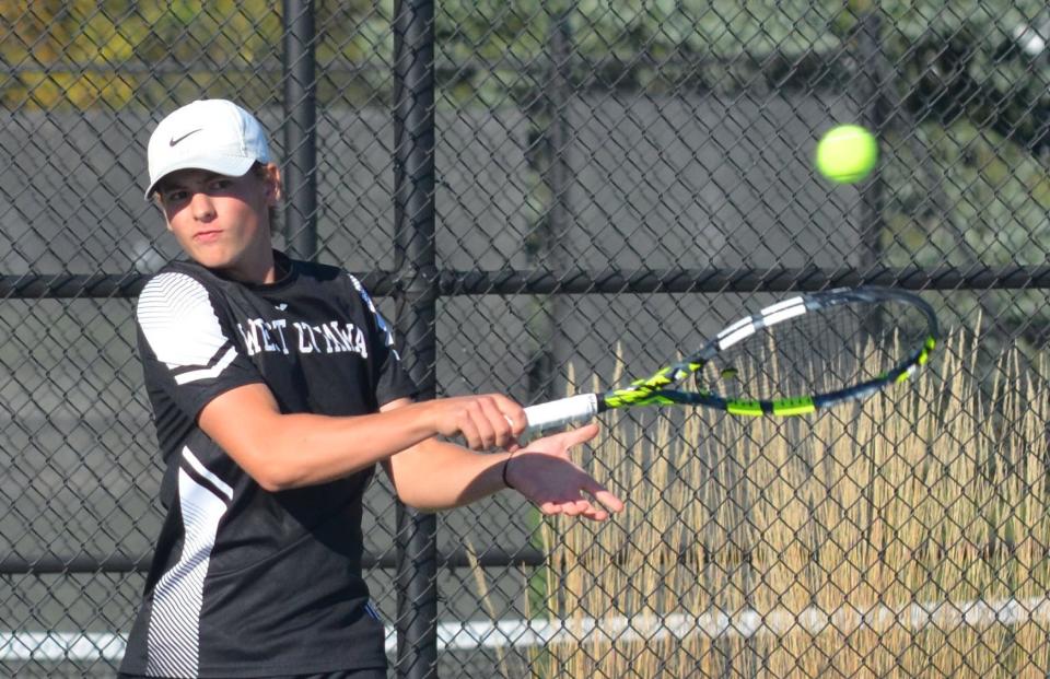 West Ottawa's Trevyn Bethke returns a shot against East Kentwood in the No. 2 singles finals at the Division 1 regional tennis tournament on Thursday at West Ottawa.