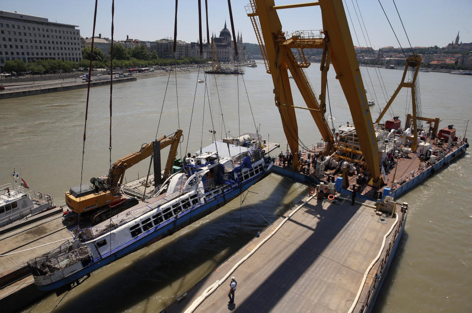 A crane lifts the sightseeing boat out of the Danube river in Budapest, Hungary, Tuesday, June 11, 2019. Eight people are still missing from the May 29 collision between the Hableany (Mermaid) sightseeing boat and the Viking Sigyn river cruise ship at Budapest's Margit Bridge. (AP Photo/Darko Bandic)