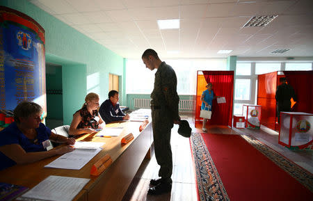 A Belarussian serviceman receives his ballot at a polling station during a parliamentary election, in Minsk, Belarus September 11, 2016. REUTERS/Vasily Fedosenko