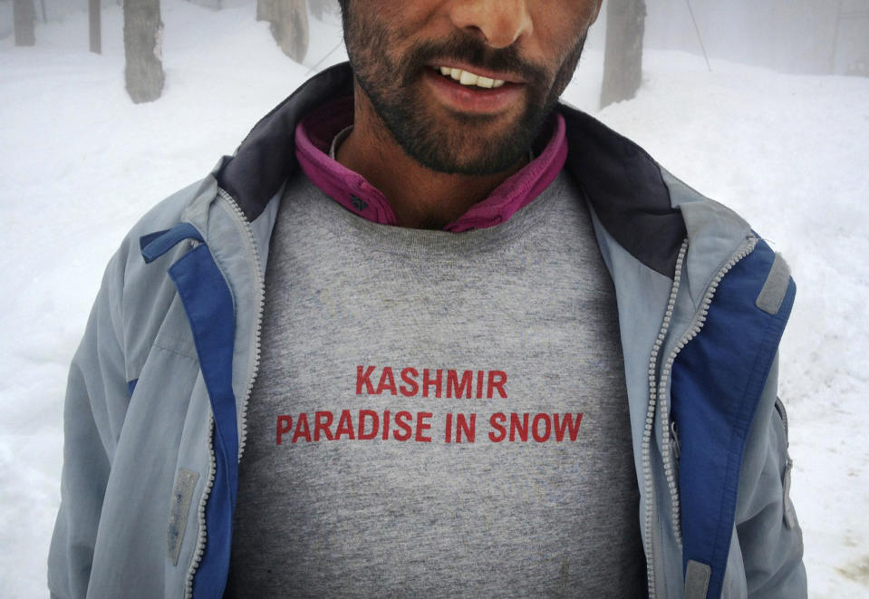 In this photo taken Saturday, Feb. 23, 2013, a Kashmiri worker wears a T-shirt at Gulmarg, Kashmir. Gulmarg, a ski resort nestled in the Himalayan mountains in Indian-held Kashmir is one of the most militarized places on earth. (AP Photo/Kevin Frayer)