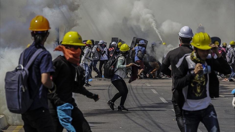 La policía disparando gas lacrimógeno contra unos manifestantes que protestan en Rangún contra el golpe militar.