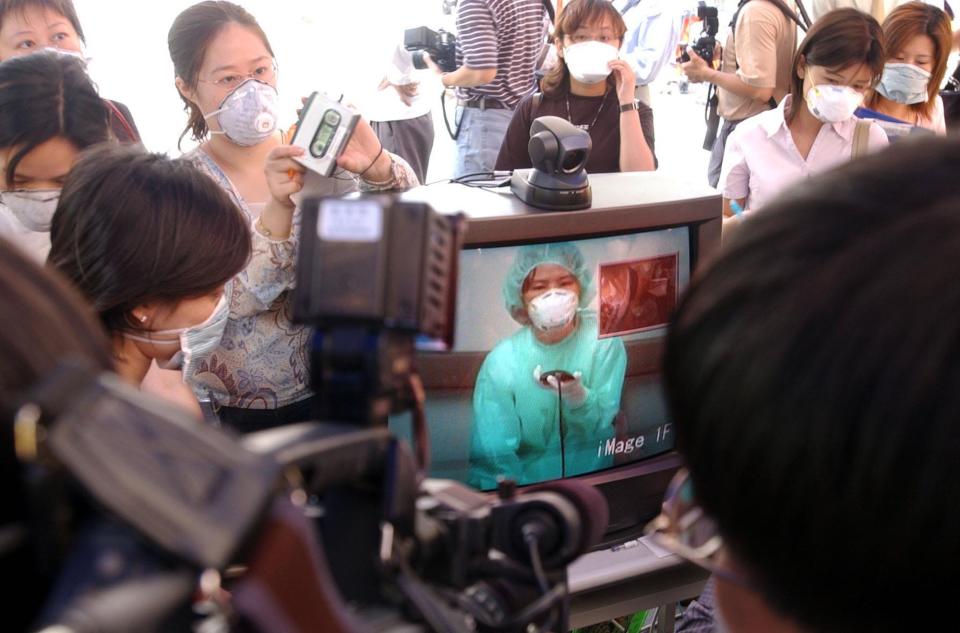 A nurse quarantined in the sealed off Taipei Municipal Hoping Hospital talks to her relatives outside the hospital through a web cam set up in the hospital, Sunday, April 27, 2003, in Taipei, Taiwan.