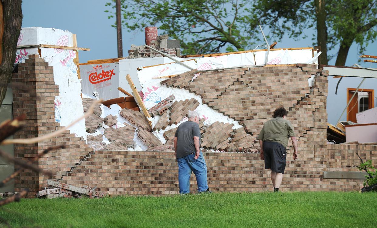 Homeowners look around at the damage after tornado touched down in Nevada, Iowa on Tuesday, May 21, 2024.