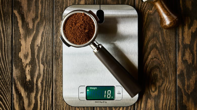 Coffee grounds in a portafilter on a kitchen scale