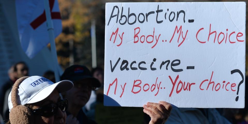 A protester holds a sign that reads: "Abortion - my body, my choice. Vaccine - my body, your choice?" at an Alberta protest against vaccine mandates, On Sunday, 24 August 2021
