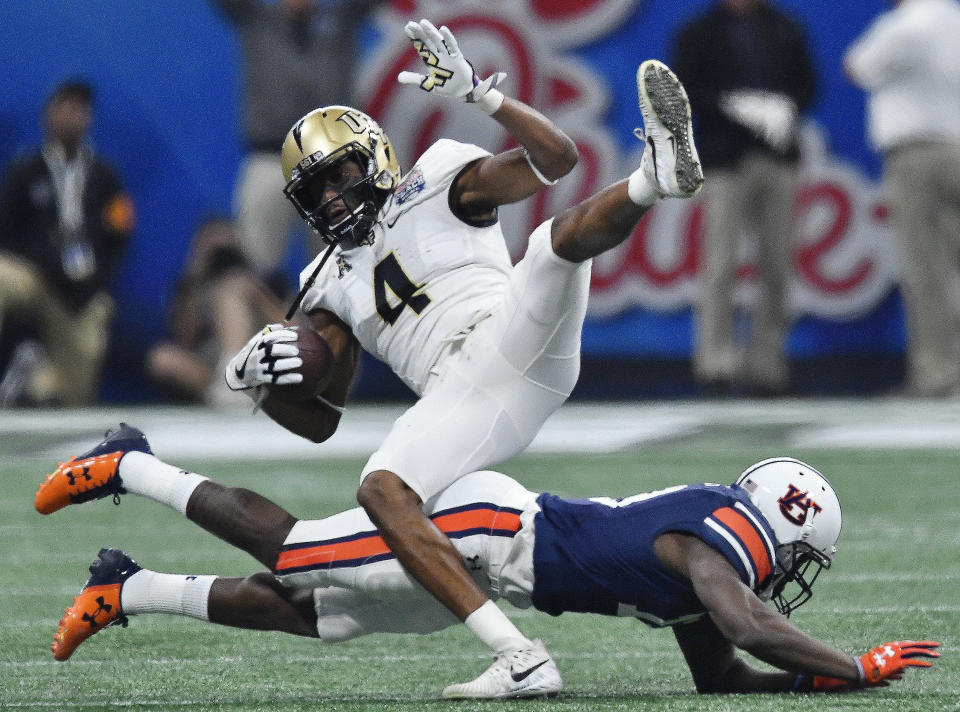 Auburn defensive back Javaris Davis (13) tackles Central Florida wide receiver Tre’Quan Smith (4) during the first half of the Peach Bowl NCAA college football game, Monday, Jan. 1, 2018, in Atlanta. (AP Photo/Mike Stewart)