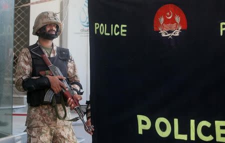 A soldier stands guard at the police screen as investigators collect evidence at the scene of a blast in a upscale neighborhood in Lahore, Pakistan February 23, 2017. REUTERS/Mohsin Raza