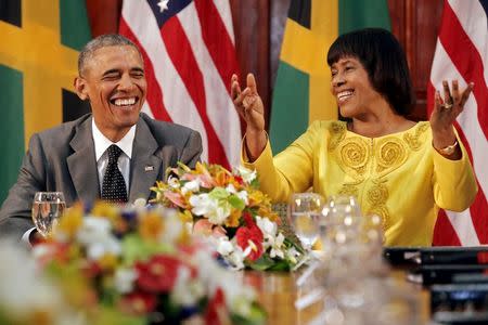 U.S. President Barack Obama (L) smiles during remarks by Jamaica's Prime Minister Portia Simpson-Miller after their meeting at Jamaica House in Kingston April 9, 2015. REUTERS/Jonathan Ernst