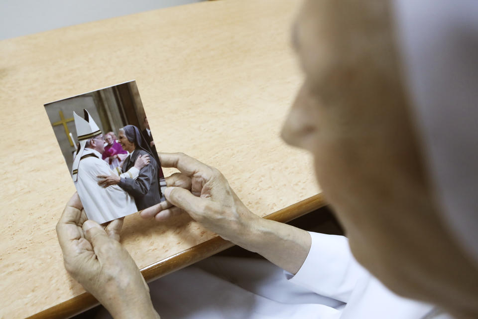 In this Aug. 27, 2019, photo, ST. Mary's School Vice Principal Sister Ana Rosa Sivori watches a picture taken with Pope Francis at the girls' school in Udon Thani, about 570 kilometers (355 miles) northeast of Bangkok, Thailand. Sister Ana Rosa Sivori, originally from Buenos Aires in Argentina, shares a great-grandfather with Jorge Mario Bergoglio, who, six years ago, became Pope Francis. So, she and the pontiff are second cousins. (AP Photo/Sakchai Lalit)