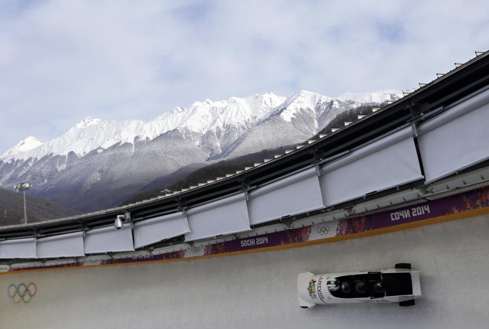 FILE - The team from Latvia LAT-1, piloted by Oskars Melbardis, take a curve during the men's four-man bobsled training at the 2014 Winter Olympics, Wednesday, Feb. 19, 2014, in Krasnaya Polyana, Russia. (AP Photo/Natacha Pisarenko, File)