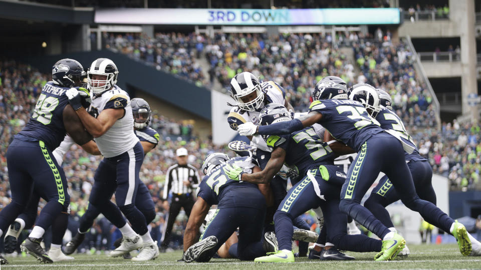 Los Angeles Rams running back Todd Gurley, center, is stopped by the Seattle Seahawks defense, including free safety Tedric Thompson (33) on a third-down goal line drive during the first half of an NFL football game, Sunday, Oct. 7, 2018, in Seattle. The Rams kicked a field goal on the next play. (AP Photo/Scott Eklund)