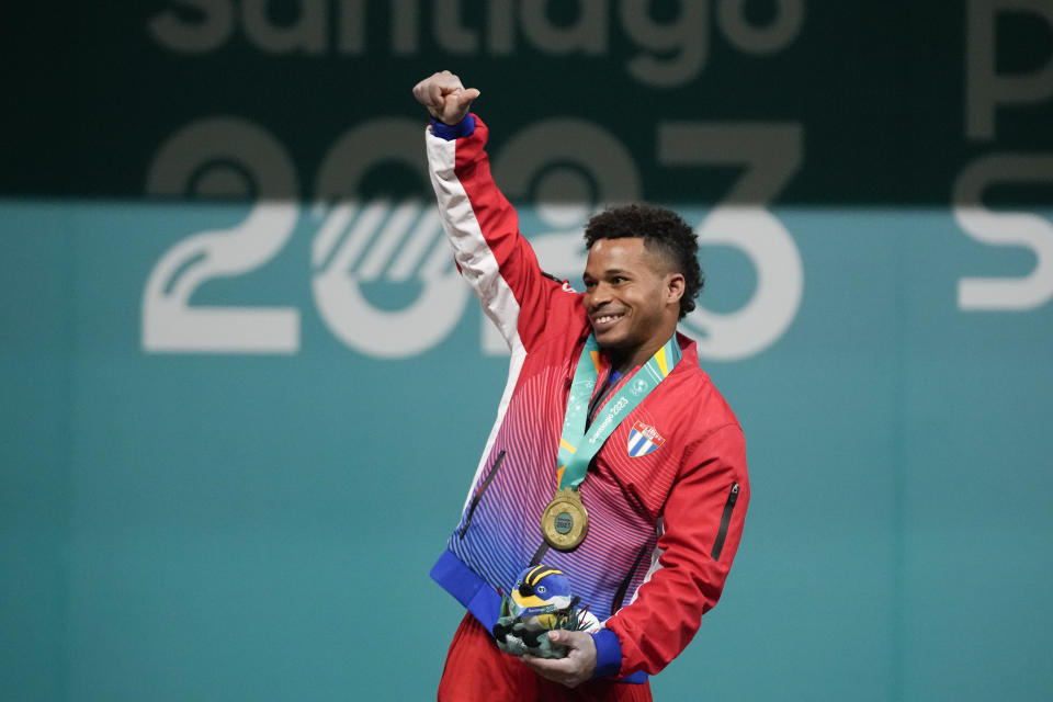 Cuba's Arley Calderon celebrates after winning the gold medal in the men's weightlifting 61Kg at the Pan American Games in Santiago, Chile, Saturday, Oct. 21, 2023. (AP Photo/Moises Castillo)