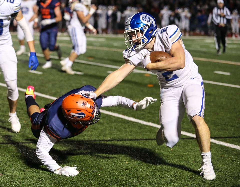 Caldwell's Harry Boland runs the ball as Mountain Lakes' Gavin Ananian defends during the first half of a football game at Mountain Lakes High School on October 21, 2022.