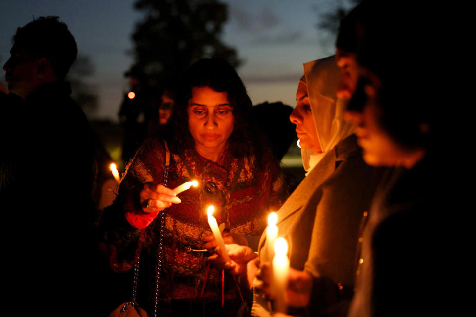 A woman uses a candle to ignite additional candles held by vigil attendees (Eileen T. Meslar / Chicago Tribune/Tribune News Service via Getty Images file)