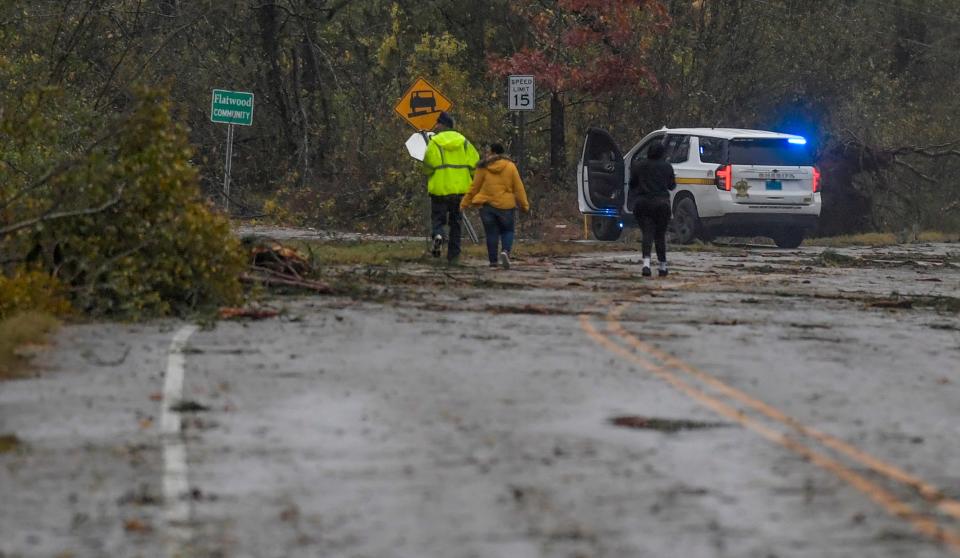 Residents walk near the Flatwood community, the scene of overnight fatal storms in Montgomery, Ala., on Wednesday morning November 30, 2022. 