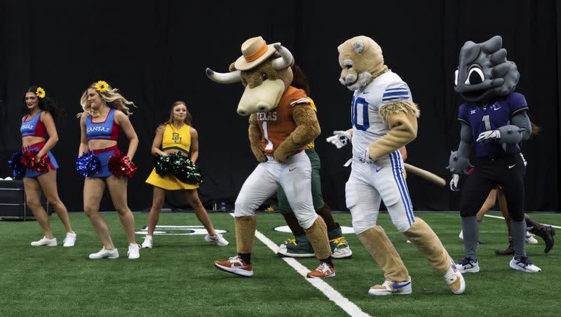 Mascots and cheerleaders from various schools dance together at the Big 12 football media days in Arlington, Texas, Thursday, July 13, 2023. 