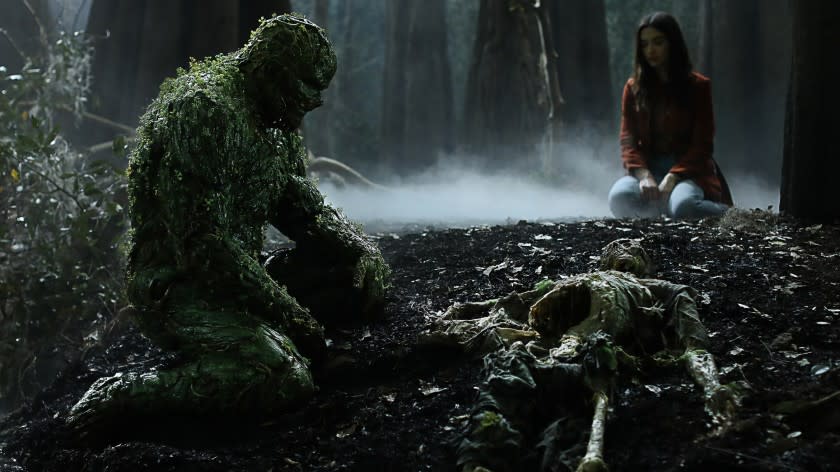 Swamp Thing -- The CW TV Series, Swamp Thing -- "Loose Ends" -- Image Number: SWP110c_0046 V1 -- Pictured (L - R): Derek Mears as Swamp Thing and Crystal Reed as Dr. Abby Arcane -- Photo: Fred Norris / 2020 Warner Bros. Entertainment Inc. -- © 2020 Warner Bros. Entertainment Inc. All Rights Reserved. Derek Mears and Crystal Reed in "Swamp Thing" on The CW.