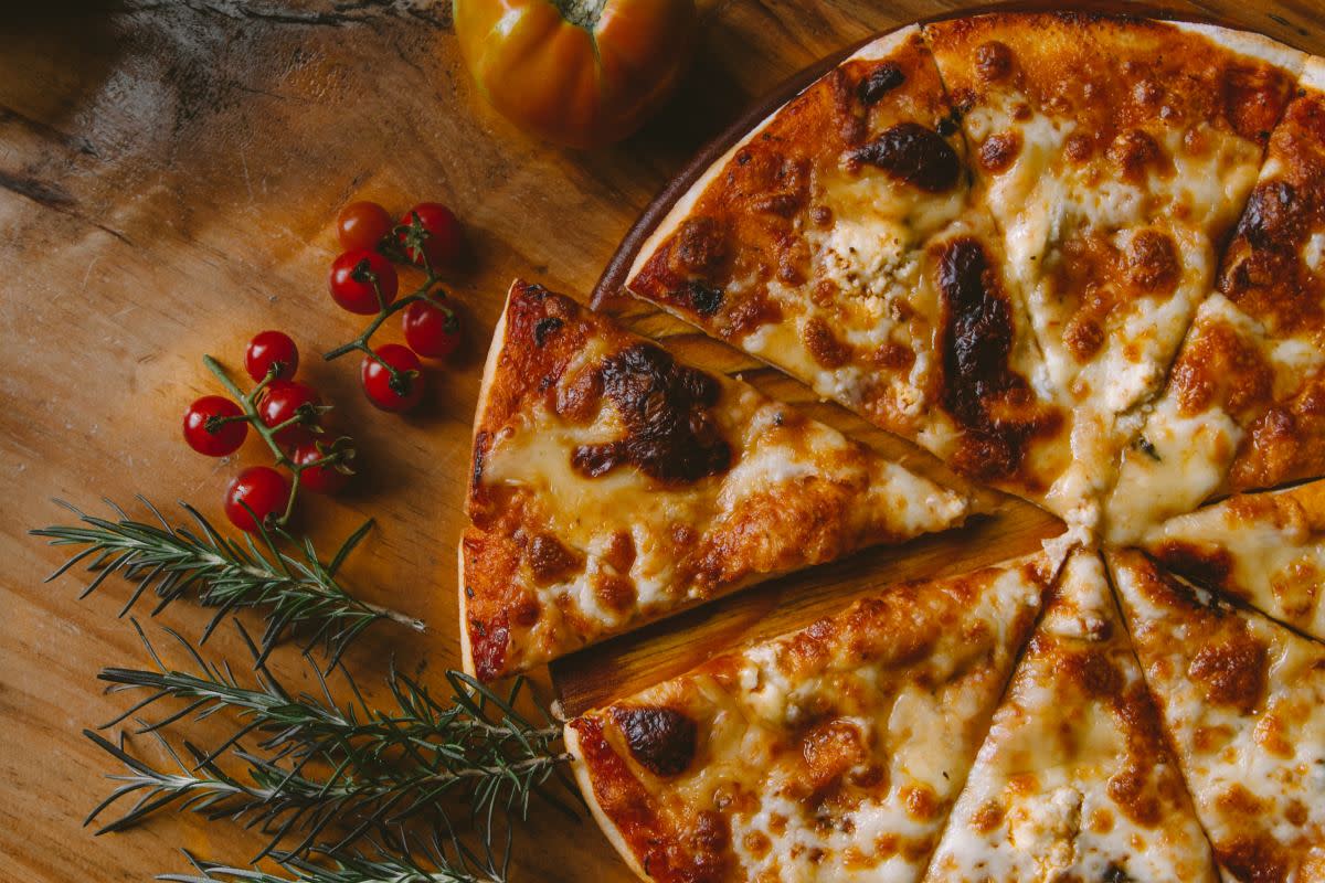 Cheese pizza cut into triangle slices for National Pizza Week on Jan. 14-20, 2024.<p>Ivan Torres/Unsplash</p>