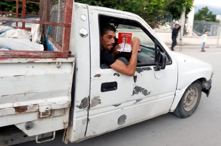 A supporter of presidential candidate Nabil Karoui displays a leaflet during a campaign in Tunis