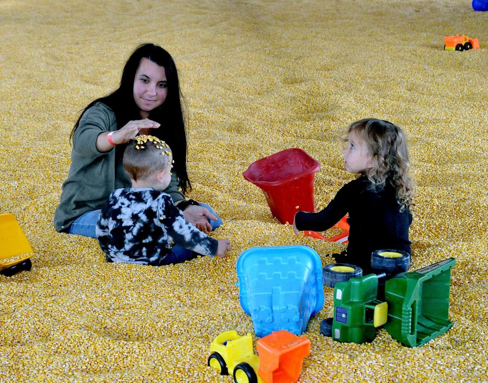 Tiffany Lacey of Doylestown and her kids Raylen and Emmi take time to play in the corn barn at Ramseyer Farm.