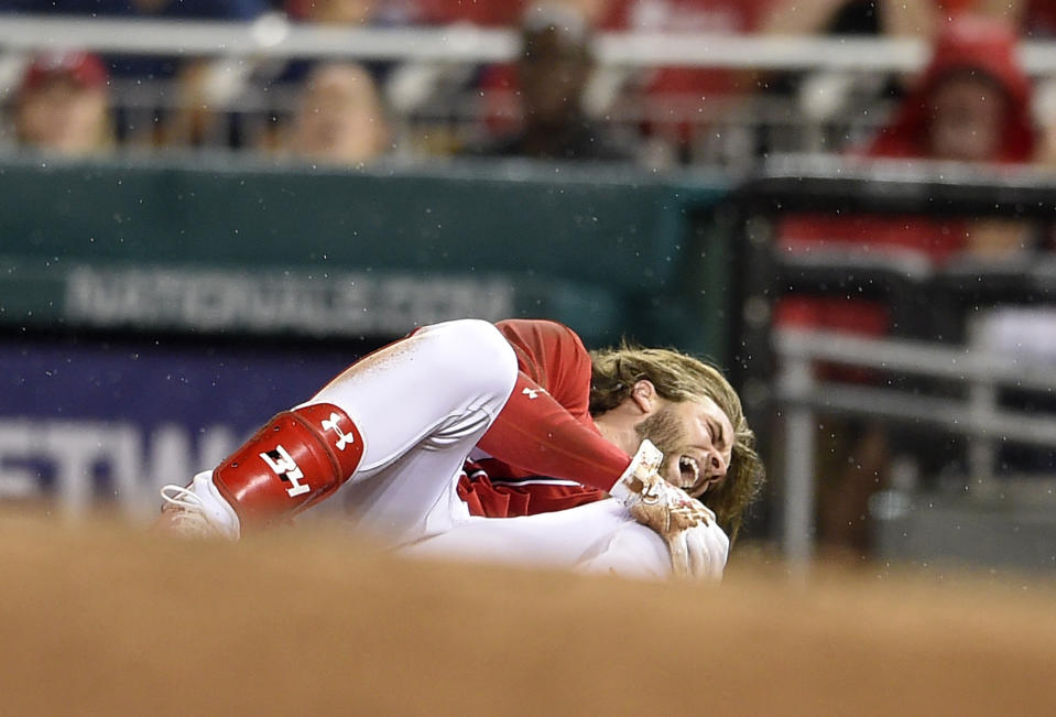 Washington Nationals' Bryce Harper grabs his knee after he was injured running to first during the first inning of the team's baseball game against the San Francisco Giants, Saturday, Aug. 12, 2017, in Washington. (AP Photo/Nick Wass)