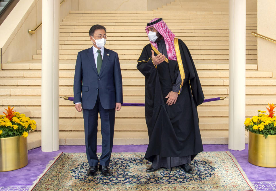 In this photo released by the Saudi Royal Palace, Saudi Crown Prince Mohammed bin Salman, right, welcomes South Korean President Moon Jae-in, at Riyadh International Airport, Saudi Arabia, Tuesday, Jan. 18, 2022. It is the latest visit by a head of state to Saudi Arabia as a growing number of world leaders resume bilateral meetings and trips abroad following COVID-19 vaccine rollouts in many parts of the world. (Bandar Aljaloud/Saudi Royal Palace via AP)