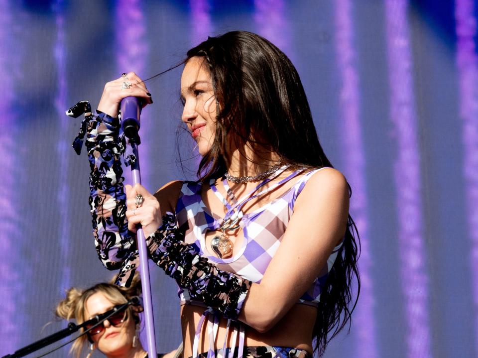 An image of Olivia Rodrigo on-stage in a purple top