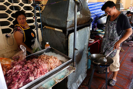 Vendors make food at their street food shop in Bangkok, Thailand April 20, 2017. REUTERS/Athit Perawongmetha