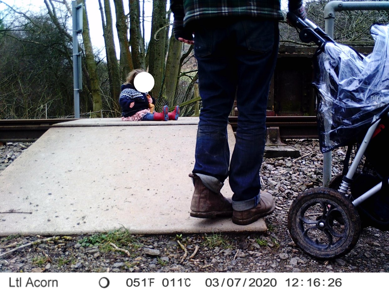 CCTV shows a toddler sitting on a level-crossing. (Network Rail)