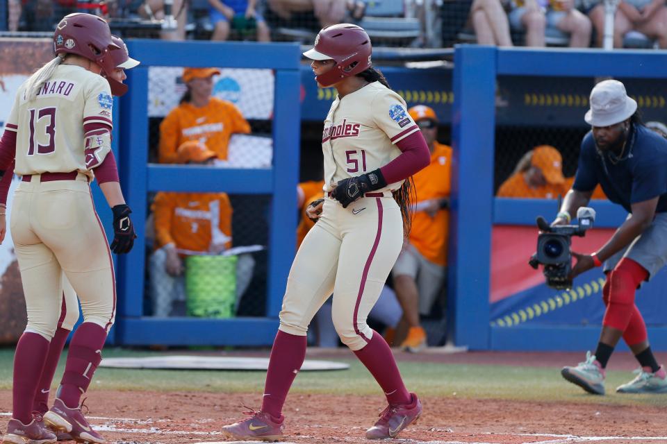 Florida State's Michaela Edenfield (51) steps on home plate near Mack Leonard (13) and Devyn Flaherty after Edenfield hit a home run against Tennessee during the second inning of an NCAA softball Women's College World Series game, Monday, June 5, 2023, in Oklahoma City. (AP Photo/Nate Billings)