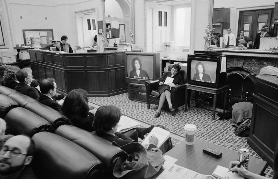 In the Senate Press Gallery, members of the press take notes and watch Monica Lewinsky testify on television, February 6, 1999 in Washington D.C.