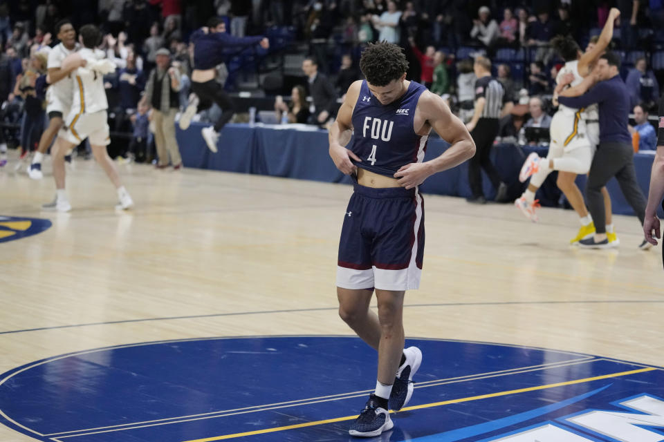 Fairleigh Dickinson guard Grant Singleton (4) walks off the court as Merrimack celebrates following the Northeast Conference men's NCAA college basketball championship game, Tuesday, March 7, 2023, in North Andover, Mass. Merrimack won 67-66. (AP Photo/Charles Krupa)