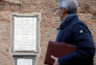 A man walks in front of a 136 year-old plaque honouring the victims of " Papal tyranny" after Pope Francis celebrated a Mass in Carpi, Italy, April 2, 2017. REUTERS/Alessandro Garofalo