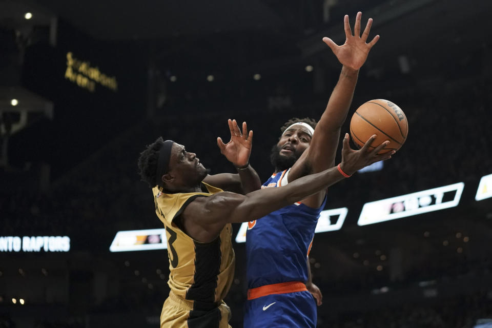 Toronto Raptors forward Pascal Siakam, left, collides with New York Knicks center Mitchell Robinson, right, during first-half NBA basketball game action in Toronto, Friday, Dec. 1, 2023. (Arlyn McAdorey/The Canadian Press via AP)