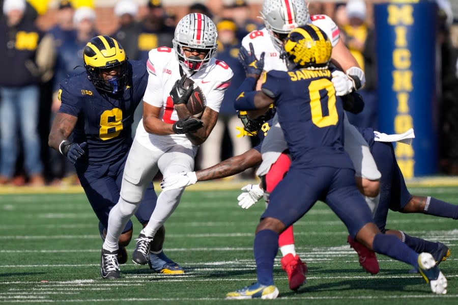 Ohio State wide receiver Xavier Johnson (0) rushes during the first half of an NCAA college football game against Michigan, Saturday, Nov. 25, 2023, in Ann Arbor, Mich. (AP Photo/Carlos Osorio)
