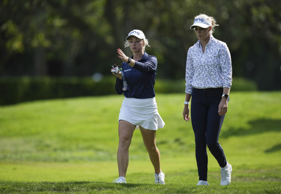 Sisters Maddie Szeryk, left, and Ellie Szeryk, of Canada, walk together on the first hole while paired during the first round of the LPGA CPKC Women's Open golf tournament in Vancouver, British Columbia, Thursday, Aug. 24, 2023. (Darryl Dyck/The Canadian Press via AP)