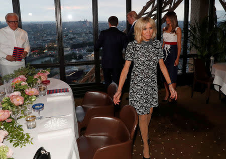 FILE PHOTO - French chef Alain Ducasse (L) watches Brigitte Macron (R), wife of French President Emmanuel Macron, who looks at the city view with U.S. President Donald Trump and First lady Melania Trump (R Rear) July 13, 2017 at the Jules Verne restaurant before a private dinner at the Eiffel Tower in Paris, France. Picture taken July 13, 2107. REUTERS/Yves Herman/FIle Photo