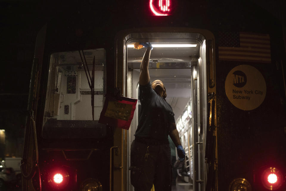 A Metropolitan Transportation Authority worker sanitizes surfaces at the Coney Island Yard, Tuesday, March 3, 2020, in the Brooklyn borough of New York. The MTA is stepping up efforts to sanitize cars and stations as fears mount over the coronavirus. (AP Photo/Kevin Hagen)