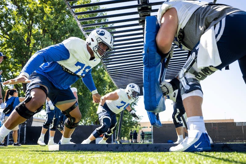 BYU offensive linemen, including Kingsley Suamataia (78) and Campbell Barrington (74), go through drills on Monday, Aug. 22, 2022.