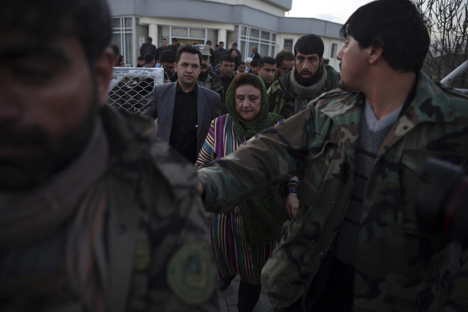 Hawa Alam Nuristani, chief of Election Commission of Afghanistan, center, leaves after a press conference at the commission's office in Kabul, Afghanistan, Tuesday, Feb. 18, 2020. Afghanistan's independent election commission says President Ashraf Ghani has won a second term as president in a vote that took place on Sept. 28 last year. (AP Photo/Rahmat Gul)