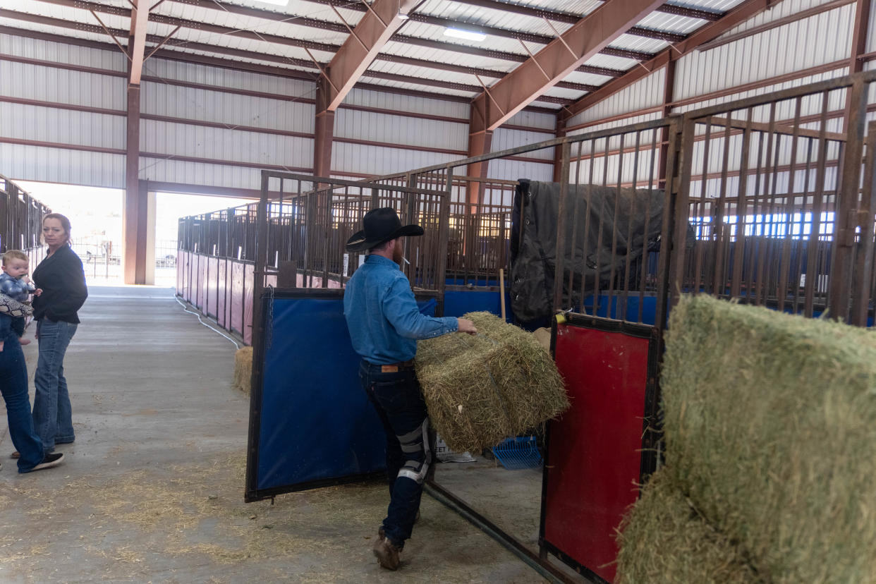 A cowboy carries hay for the horses at the Pavilion at the Santa Fe Depot Wednesday across from the Amarillo Civic Center Wednesday for the WRCA Rodeo which has events through Sunday.