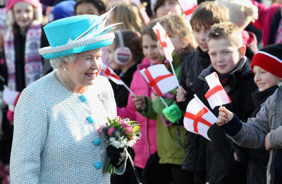 KING'S LYNN, ENGLAND - FEBRUARY 06: Queen Elizabeth II smiles as children wave flags during a visit to Dersingham School on February 6, 2012 in King's Lynn, England. The Queen made the visit to the school as she celebrates Accession Day and 60 years on the throne. (Photo by Chris Jackson/Getty Images)