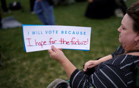 Beth Walsh holds a sign as teens kick off a voter registration rally, a day ahead of the 19th anniversary of the massacre at Columbine High School, in Littleton, Colorado, U.S., April 19, 2018. REUTERS/Rick Wilking