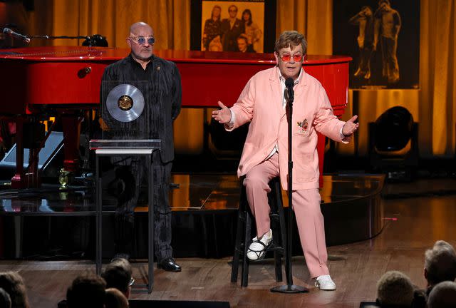 <p>Kevin Mazur/Getty</p> Bernie Taupin and Elton John speaking onstage during the Library Of Congress 2024 Gershwin Prize for Popular Song