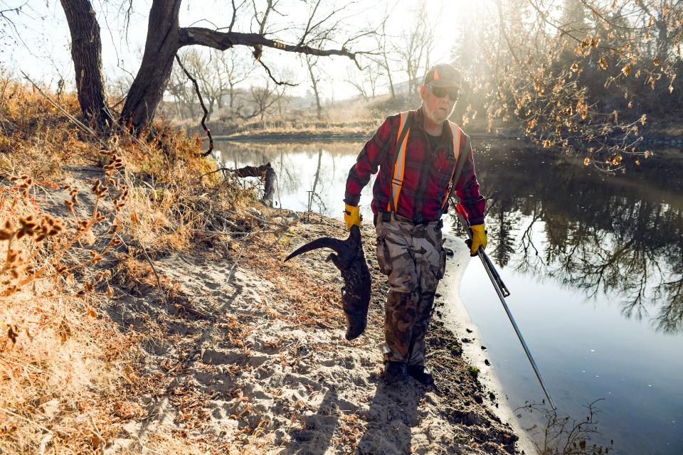 Mike Kroger carries an otter he caught as he checks his remaining traps on Thursday, November 5 at the Big Sioux River in Dell Rapids.