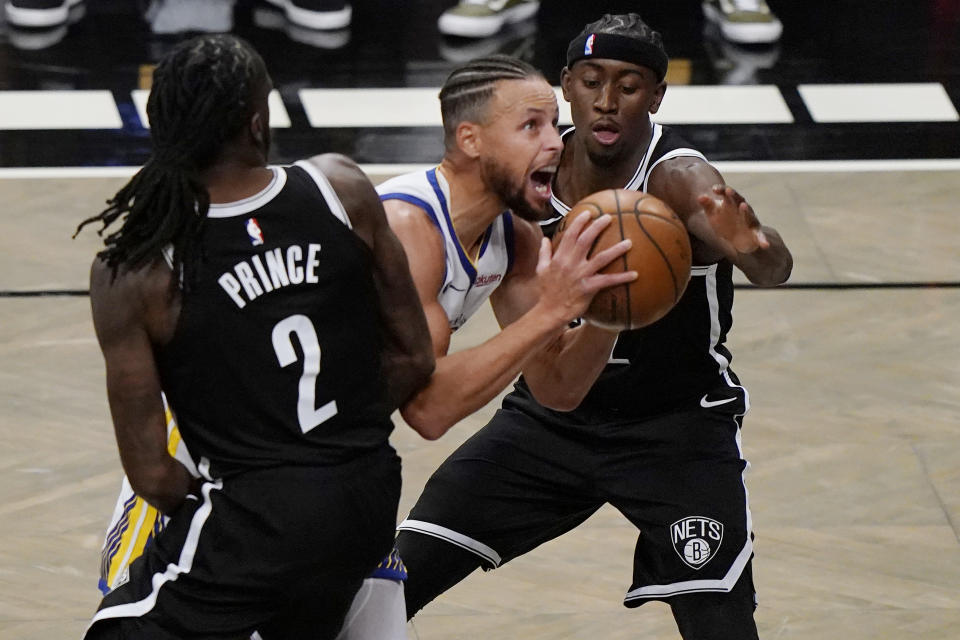 Brooklyn Nets forward Taurean Prince (2) and Brooklyn Nets guard Caris LeVert (22) defend Golden State Warriors guard Stephen Curry (30) as Curry looks to shoot during the first quarter of an opening night NBA basketball game, Tuesday, Dec. 22, 2020, in New York. (AP Photo/Kathy Willens)