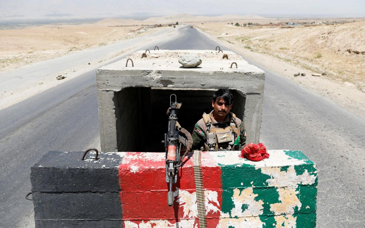 An Afghan National Army soldier stands guard at a checkpoint near Bagram U.S. air base, on the day the last of American troops vacated it, Parwan province, Afghanistan July 2, 2021. REUTERS/Mohammad Ismail