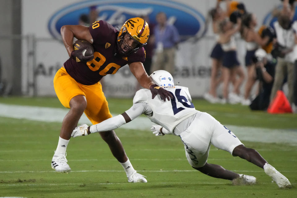 Arizona State tight end Messiah Swinson (80) avoids the tackle attempt by Northern Arizona defensive back Colby Humphrey during the first half of an NCAA college football game Thursday, Sept. 1, 2022, in Tempe, Ariz. (AP Photo/Rick Scuteri)