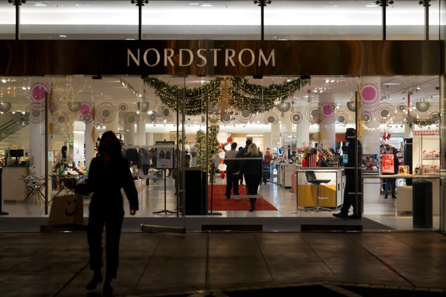 File – A security guard, right, stands at the entrance to a Nordstrom department store in Los Angeles, Dec. 2, 2021, where a smash-and-grab robbery took place. The National Retail Federation, the nation’s largest retail trade group, has revised a report released in April that pulls back the claim that organized retail crime accounts for nearly half of overall industry shrink, which measures overall loss in inventory, including theft. (AP Photo/Jae C. Hong, File)